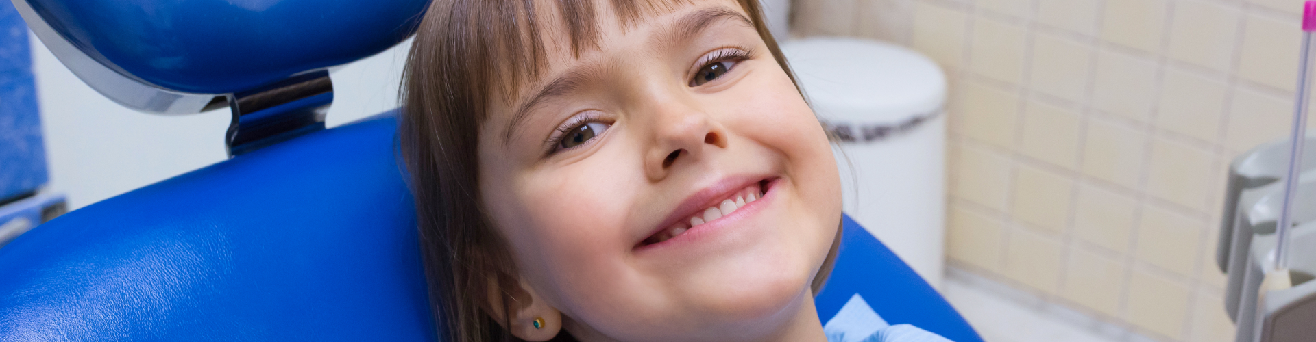 Face of smiling girl in dental chair.